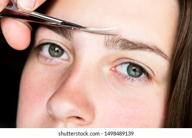 Woman Trimming Eyebrows With Scissors. Eyebrow Correction.