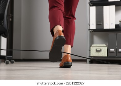 Woman Tripping Over Cable In Office, Closeup