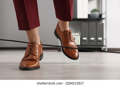 Woman Tripping Over Cable In Office, Closeup