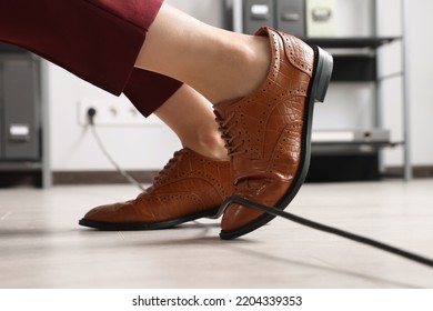 Woman Tripping Over Cable In Office, Closeup