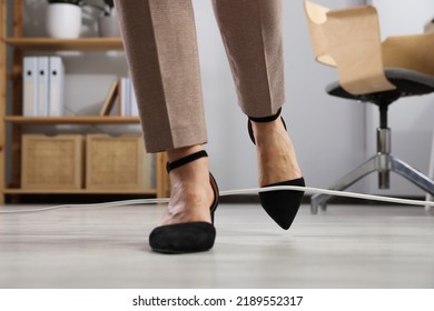 Woman Tripping Over Cord In Office, Closeup