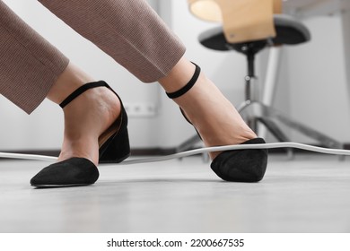 Woman Tripping Over Cord In Office, Closeup