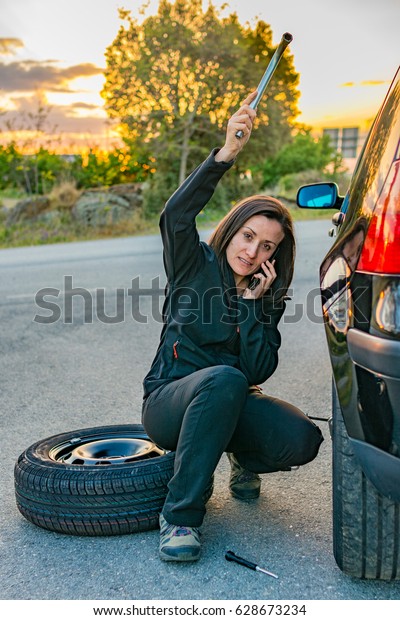 Woman in trouble\
trying to change a wheel