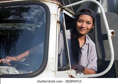 Woman Truck Driver In The Truck Looking Out From Window. Asian Woman Driving A Lorry. Young Woman Looking Out The Window Trucks. Woman Driving An Old Truck. Truck Driver In Asia. Driving An Old Lorry.