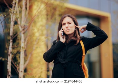 
Woman Trying To Have A Phone Conversation In A Noisy City. Frustrated Businesswoman Trying To Speak On Her Mobile Phone Out In The Street
