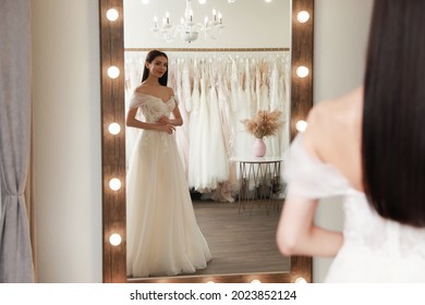 Woman trying on beautiful wedding dress in boutique - Powered by Shutterstock