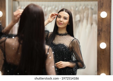 Woman Trying On Dress In Clothing Rental Salon