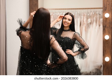 Woman Trying On Dress In Clothing Rental Salon