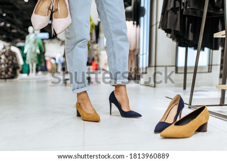 Woman trying on shoes in store, view on feets