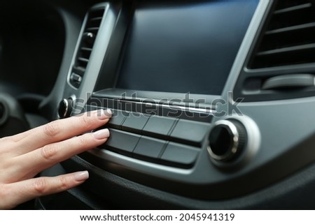 Woman tuning radio in car, closeup