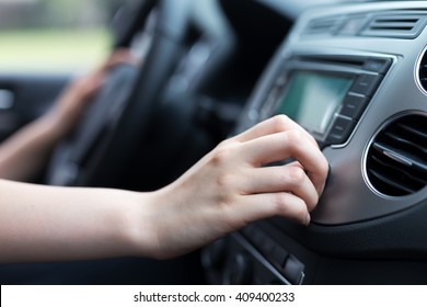 Woman Turning Button Of Radio In Car