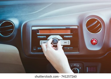 Woman Turning Button Of Radio In Car