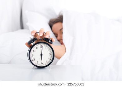 Woman Turning Off The Alarm Clock