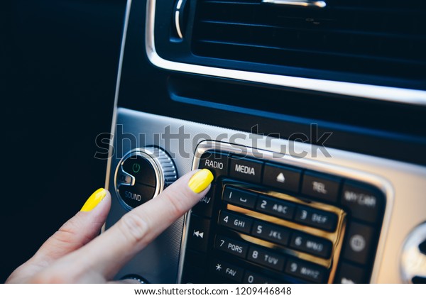 Woman turning on car navigation system. Modern\
car interior