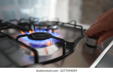 Woman turning on the gas burner on the stove. - Shutterstock ID 2277294059