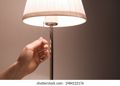 Woman Turning On Glowing Lamp, Closeup