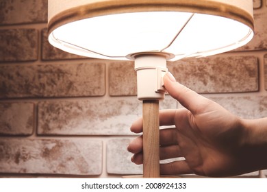 Woman Turning On Glowing Lamp, Closeup