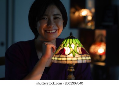 Woman Turning On A Stained Glass Lamp 