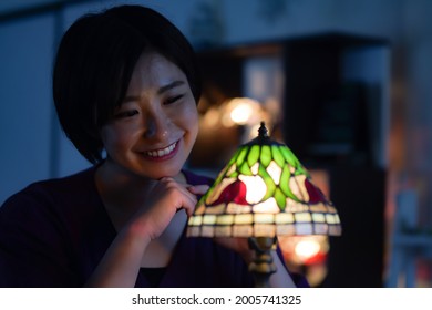 Woman Turning On A Stained Glass Lamp 
