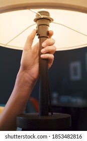 Woman Turning On A Table Lamp At Home, Hand Close Up