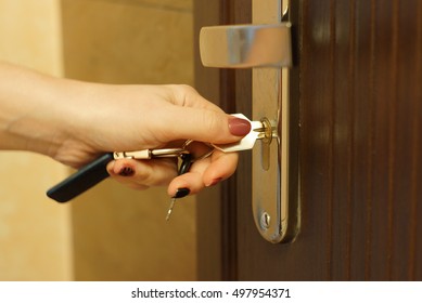 The woman turns the key in the lock on the outside door open