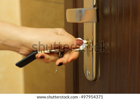The woman turns the key in the lock on the outside door open