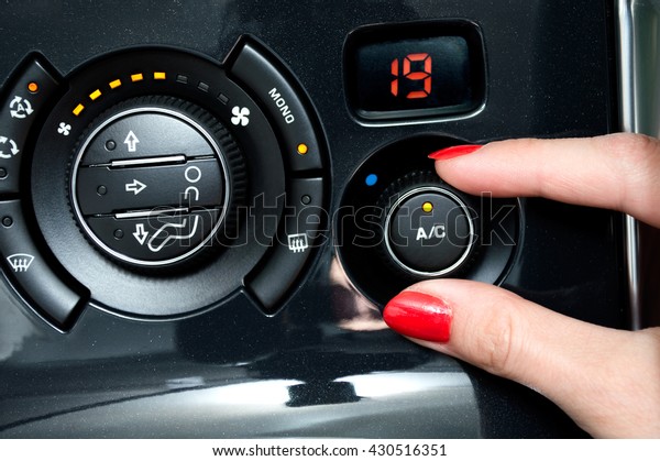 Woman turns on air\
conditioning in a car