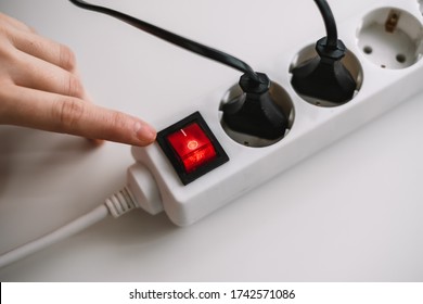 A Woman Turns On An Electric Surge Protector. Protection Of Household Appliances From Electrical Interference. Home Safety