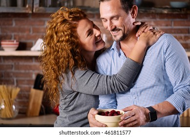Woman twining hands around neck of man