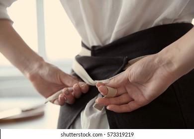 Woman  tying up her apron around the waist - Powered by Shutterstock