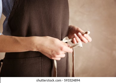 Woman  tying up her apron around the waist - Powered by Shutterstock