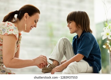 Woman tying her grandsons shoelaces. - Powered by Shutterstock