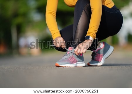 woman tying her running shoes in the park