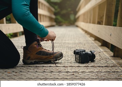 Woman Tying Hiking Shoes With Camera On The Floor In Outdoors.