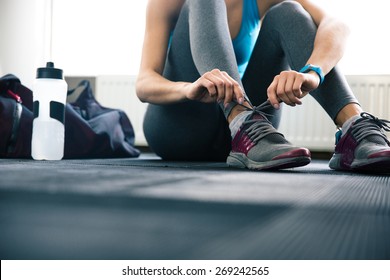 Woman Tying Shoelaces At Gym