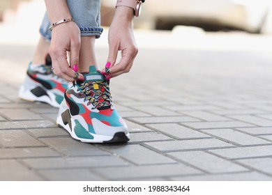 Woman Tying Shoelaces On Sports Sneakers Closeup