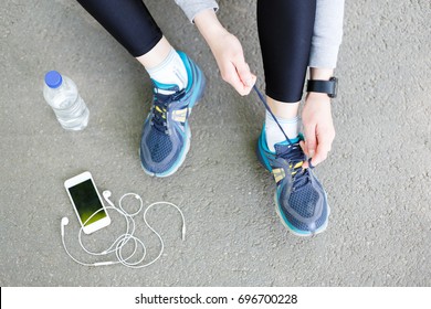 Woman Tying Shoes Laces Before Running, Getting Ready For Jogging In Park, Top View