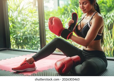 woman tying tape around her hand before get boxing gloves preparing to boxing practice.	