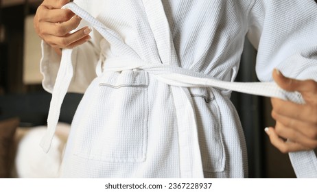 Woman tying White Bathrobe after shower, living lifestyle - Shutterstock ID 2367228937