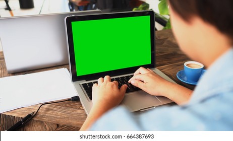 Woman Typing On Keyboard Laptop Computer And Green Screen With Soft Focus For Technology Communication Background