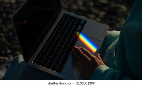 A woman is typing laptop  Rainbow light from prism  