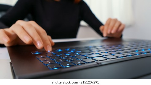 Woman Typing On A Laptop With An RGB Keyboard.