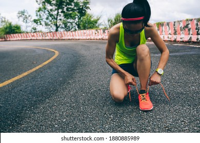 Woman Ultra Marathon Runner Tying Shoelace On Rainforest Trail