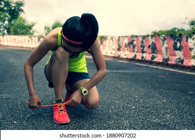 Woman Ultra Marathon Runner Tying Shoelace On Rainforest Trail