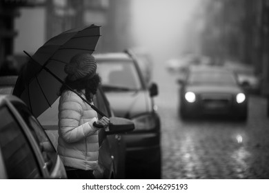 Woman With An Umbrella On A Foggy City Street. Black And White Photo.