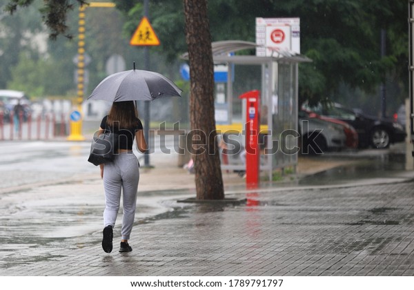 woman with\
umbrella on the street in the\
rain