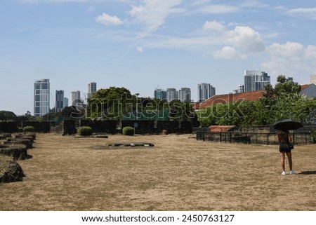Woman with umbrella in the sun in field in Manila on March 29, 2024