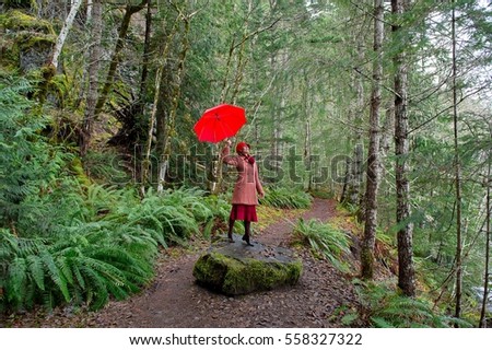 Woman with umbrella walking in forest