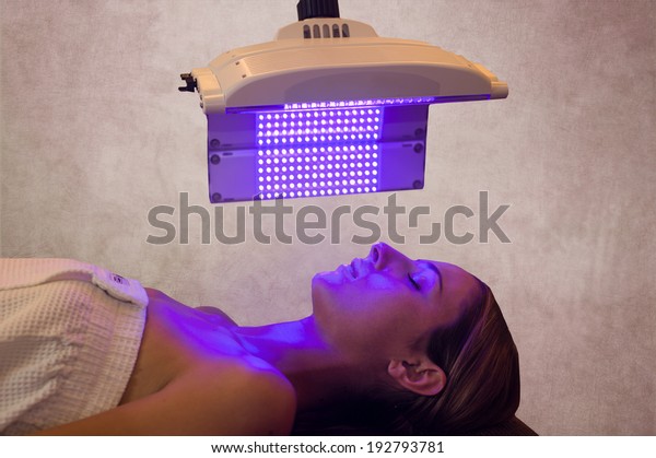 a woman\
under a light therapy machine, blue\
light
