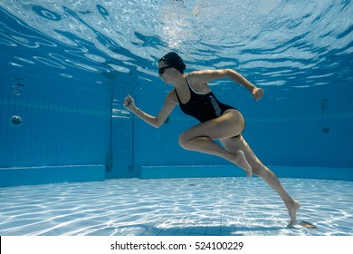 Woman Under Water Runs Along The Bottom Of A Swimming Pool